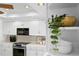 White kitchen features a built-in microwave and white cabinets at 3111 E Vina Del Mar Blvd, St Pete Beach, FL 33706