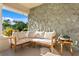 Relaxing front porch with stone wall and comfortable seating area at 3111 E Vina Del Mar Blvd, St Pete Beach, FL 33706