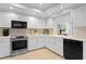 White kitchen with stainless steel appliances and a corner sink at 3111 E Vina Del Mar Blvd, St Pete Beach, FL 33706