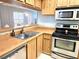 View of kitchen with wood cabinets, stainless steel appliances, and a double sink at 2983 Bonaventure Cir # 103, Palm Harbor, FL 34684