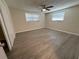 Spacious bedroom with wood-look floors, ceiling fan, and large closet at 10911 Oldham Rd, Port Richey, FL 34668