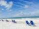 Blue beach chairs on a pristine, white sand beach at 3118 Palm Ct, Dunedin, FL 34698
