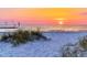 Stunning sunset over a tranquil beach with white sand and sea oats at 3118 Palm Ct, Dunedin, FL 34698