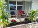 Small front porch with seating and tropical plants at 3118 Palm Ct, Dunedin, FL 34698