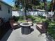 Backyard patio with fire pit and seating area, surrounded by trees at 3118 Palm Ct, Dunedin, FL 34698