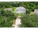 Aerial view of a two-story house with a driveway, surrounded by lush green trees at 11154 Creek Haven Dr, Riverview, FL 33569