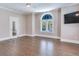 Hardwood floor bedroom with large window and mirrored closet door at 2509 N Dundee St, Tampa, FL 33629