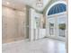 Elegant bathroom with marble floors, a walk-in shower, and a large window at 2509 N Dundee St, Tampa, FL 33629