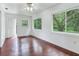 Living room with hardwood floors and large windows overlooking backyard at 7301 Pierce Harwell Rd, Plant City, FL 33565