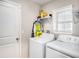 Bright laundry room features washer, dryer, and ample shelving at 16762 Delia St, Wimauma, FL 33598