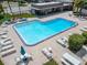 L-shaped pool with plenty of lounge chairs and tables for entertaining at 4600 Marine Parkway # 104, New Port Richey, FL 34652