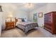 Second bedroom with double bed and wooden dresser at 37601 Neukom Ave, Zephyrhills, FL 33541