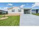 White single-wide home with carport and landscaped yard at 37601 Neukom Ave, Zephyrhills, FL 33541