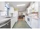 Efficient kitchen with white cabinets and view to dining area at 37601 Neukom Ave, Zephyrhills, FL 33541