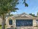 One story home with a blue garage door and mature tree at 1424 Delano Trent St, Ruskin, FL 33570