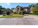 Stunning stone and stucco two-story home with a three-car garage and manicured landscaping at 909 Shoals Landing Dr, Brandon, FL 33511