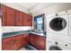 Laundry room with wood cabinets, granite countertops, and a washer and dryer at 909 Shoals Landing Dr, Brandon, FL 33511