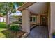 Inviting front porch with tiled flooring, decorative plants, and textured column with an enhanced front door at 13805 Candidate Pl, Tampa, FL 33613