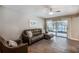 Comfortable living room featuring a modern leather sofa, neutral decor, and sliding glass doors leading to outdoor pool at 13805 Candidate Pl, Tampa, FL 33613