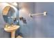 Updated bathroom with pedestal sink, oval mirror, and stylish finishes at 26607 Chimney Spire Ln, Wesley Chapel, FL 33544