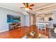 Living room featuring hardwood floors, large TV, and comfortable furniture at 26607 Chimney Spire Ln, Wesley Chapel, FL 33544