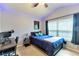 Bright bedroom with a queen bed, workspace, and large window at 26607 Chimney Spire Ln, Wesley Chapel, FL 33544