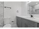 Modern bathroom with gray vanity, marble tile, and a frameless mirror at 10316 Fernbrook Ln, Tampa, FL 33624