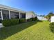 A vibrant green lawn and manicured hedges accent the rear exterior and screened-in patio of this well-kept home at 1745 Harbor W Cir, Largo, FL 33770