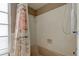 Bathroom featuring a shower-tub combo, a shower curtain, and white tiled walls at 1745 Harbor W Cir, Largo, FL 33770
