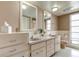 Bathroom with double sinks, double mirrors, drawers, cabinets, and a window at 1745 Harbor W Cir, Largo, FL 33770