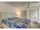 Bright bedroom featuring a queen bed with a quilt, white walls and matching closet doors at 1745 Harbor W Cir, Largo, FL 33770