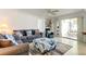 Living room showcasing comfortable sofas, an ottoman, and access to the outdoor patio at 1745 Harbor W Cir, Largo, FL 33770