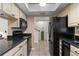 Efficient kitchen layout with black appliances, cream cabinetry, and convenient access to other areas at 5313 Bayshore Blvd # 5313, Tampa, FL 33611
