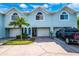 Light blue three-unit building with attached garages and a palm tree at 639 Garland Cir, Indian Rocks Beach, FL 33785