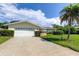 Two-car garage with a white door and a long driveway at 1745 Harbor W Cir, Largo, FL 33770