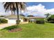 House exterior with palm tree, lawn, and two-car garage at 1745 Harbor W Cir, Largo, FL 33770