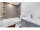 Updated bathroom with gray tile, white tub, and gray vanity at 17920 Gulf Blvd # 205, Redington Shores, FL 33708