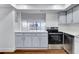 Modern kitchen with light blue cabinets, stainless steel appliances, and dark brown wood-look flooring at 17920 Gulf Blvd # 205, Redington Shores, FL 33708