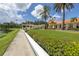 Community clubhouse with a lawn, hedges, and a lake view at 4780 Dolphin Cay S Ln # 501, St Petersburg, FL 33711