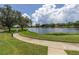 Curved path alongside a lake in a lush, green community at 4780 Dolphin Cay S Ln # 501, St Petersburg, FL 33711