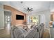 Spacious living room with vaulted ceiling, L-shaped sofa, and sliding glass doors at 11070 Labrador Duck Rd, Weeki Wachee, FL 34614