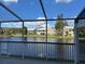 Scenic water view from a screened lanai, showcasing nearby buildings and landscaping at 1873 Mazo Mnr # T2, Lutz, FL 33558
