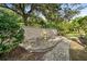 Relaxing brick patio with seating area, surrounded by lush landscaping and a stone wall at 918 Shoals Landing Dr, Brandon, FL 33511