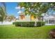 Expansive backyard featuring lush lawn, manicured hedges, and an enclosed pool area, ideal for outdoor living at 1935 Lago Vista Blvd, Palm Harbor, FL 34685