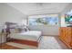 Bright bedroom with a large window, comfortable bed, and hardwood floors, showcasing a peaceful retreat at 1935 Lago Vista Blvd, Palm Harbor, FL 34685