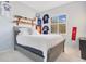 Comfortable bedroom with a wooden bed frame, light-colored walls, and sports memorabilia displayed on the walls at 1935 Lago Vista Blvd, Palm Harbor, FL 34685
