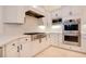 Well-equipped kitchen with stainless steel appliances, white cabinets and quartz countertops at 1935 Lago Vista Blvd, Palm Harbor, FL 34685