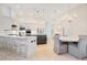 Modern kitchen with white cabinets, stainless steel appliances, and an island with seating and an adjacent dining area at 1935 Lago Vista Blvd, Palm Harbor, FL 34685