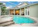 The screen-enclosed pool with a fountain and a spa is surrounded by the house, inviting relaxation and leisure at 1935 Lago Vista Blvd, Palm Harbor, FL 34685