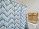 Bathroom with shower, white toilet and blue chevron shower curtain at 22834 Roderick Dr, Land O Lakes, FL 34639